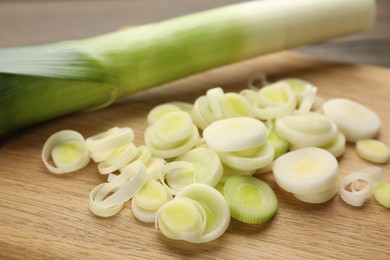 Fresh raw leek slices on wooden table, closeup