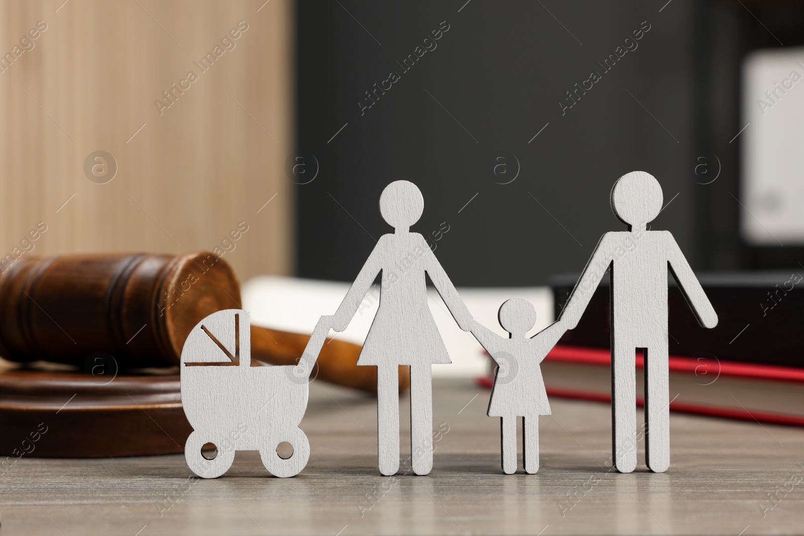 Photo of Family law. Figure of parents with children, books and gavel on wooden table