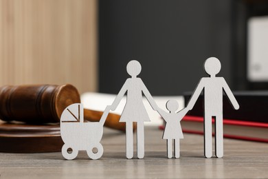 Photo of Family law. Figure of parents with children, books and gavel on wooden table