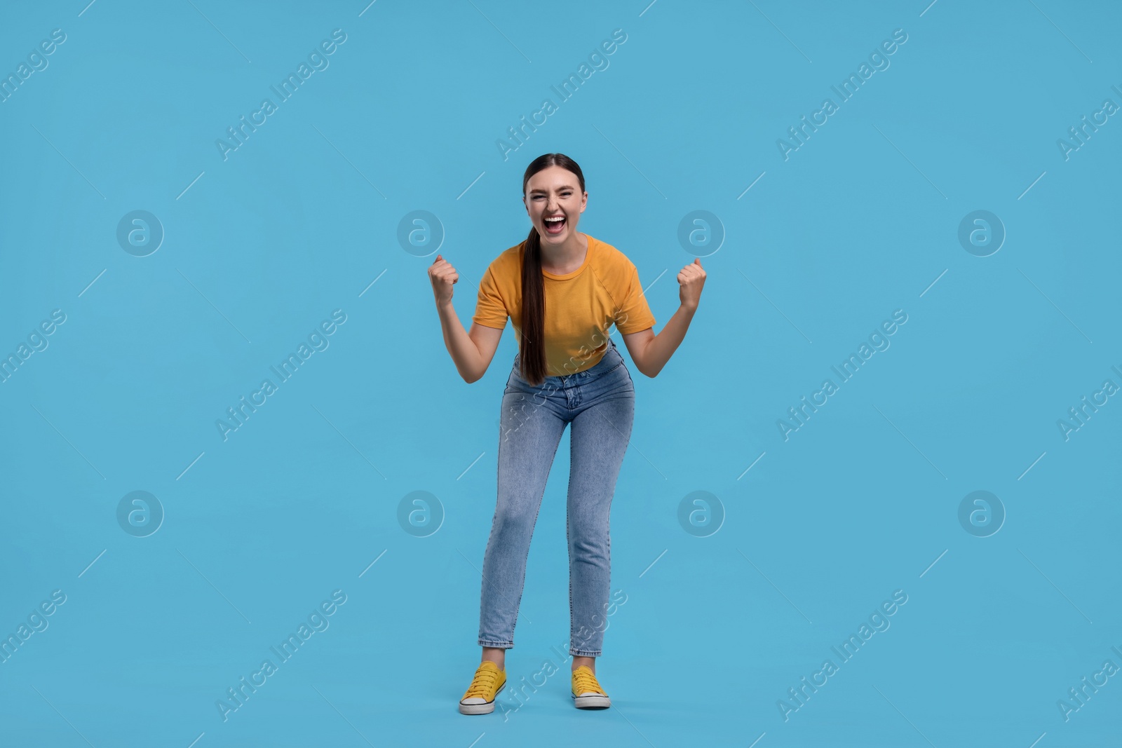 Photo of Happy sports fan on light blue background