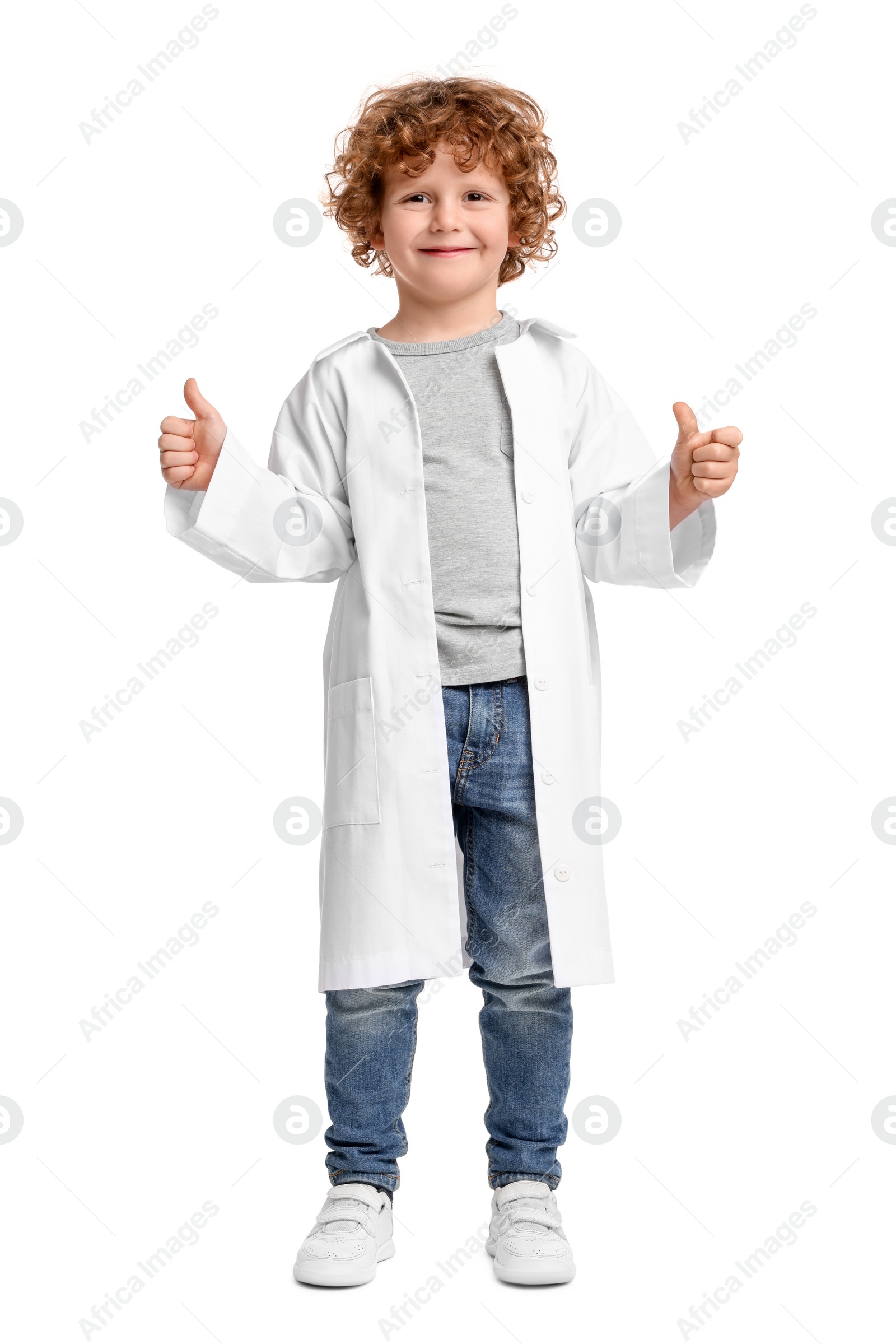 Photo of Little boy in medical uniform showing thumbs up on white background