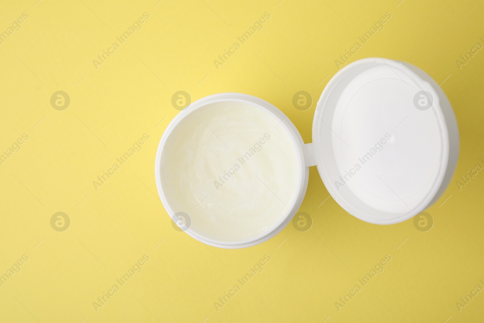 Photo of Bottle of petroleum jelly on yellow background, top view