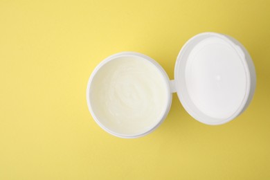 Photo of Bottle of petroleum jelly on yellow background, top view