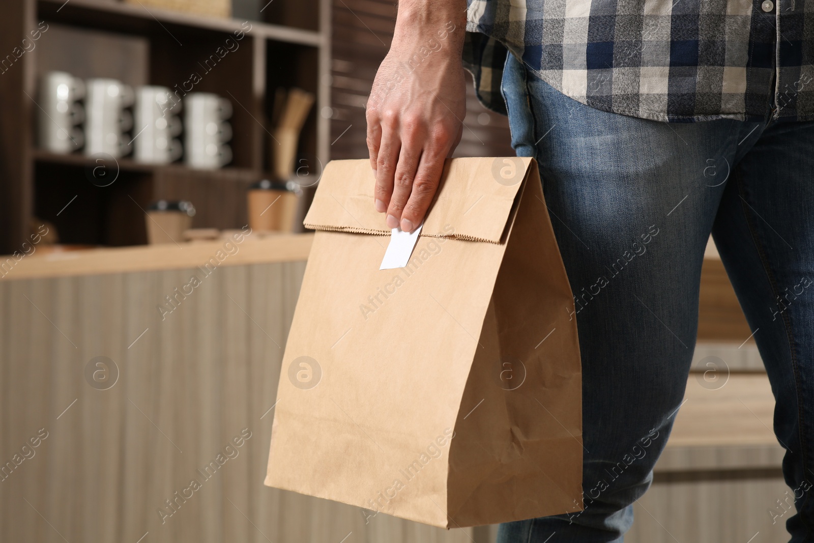 Photo of Man with paper bag in cafe, closeup. Space for text