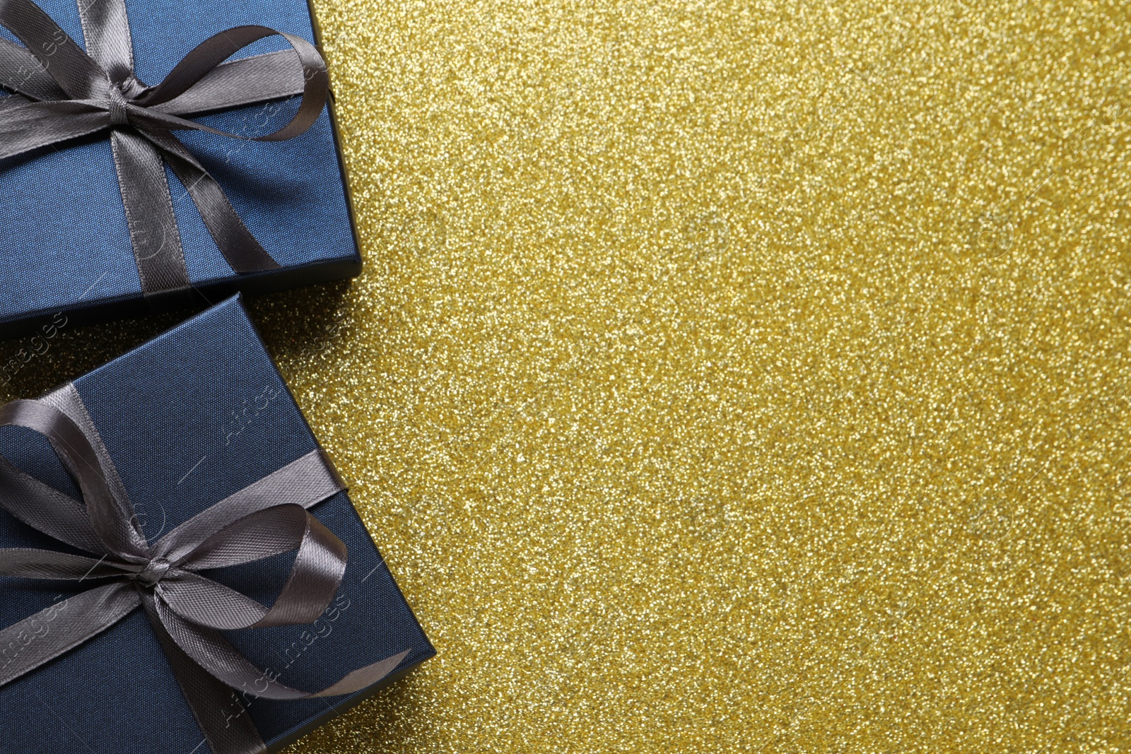 Photo of Blue gift boxes on golden background, flat lay. Space for text