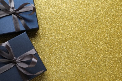 Blue gift boxes on golden background, flat lay. Space for text