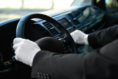 Photo of Professional driver in luxury car, closeup. Chauffeur service