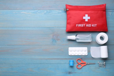 Photo of Flat lay composition with first aid kit on blue wooden table, space for text