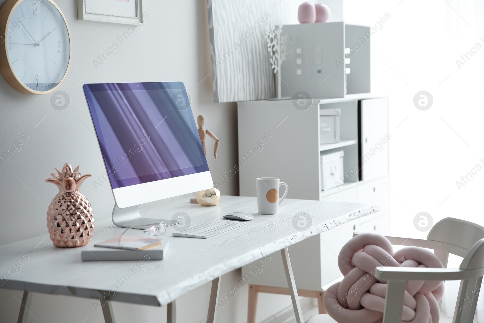 Photo of Contemporary workplace with computer on table near white wall. Interior design