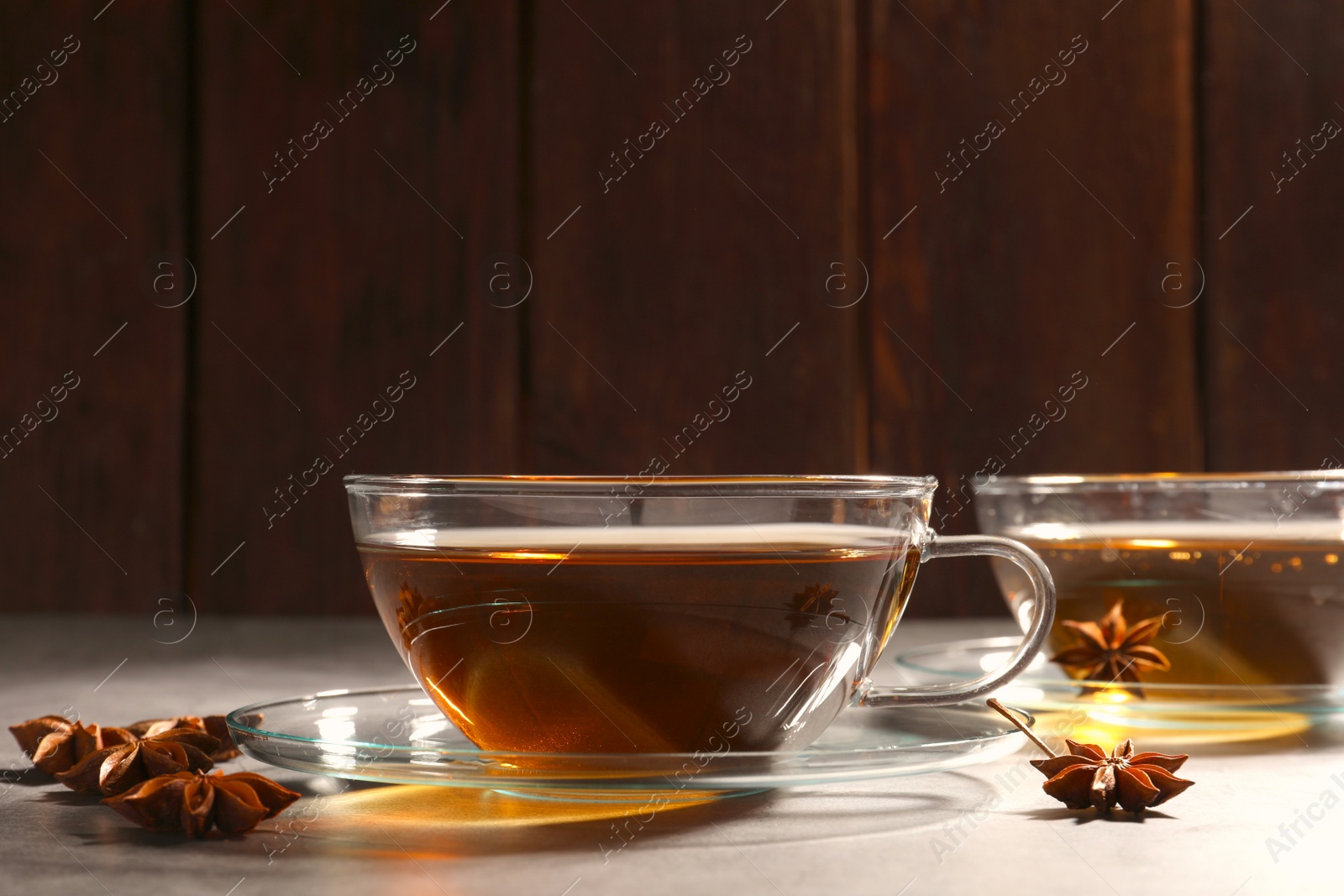 Photo of Aromatic tea with anise stars on light grey table