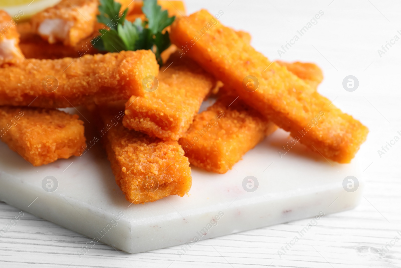 Photo of Tasty fresh fish fingers served on white wooden table, closeup