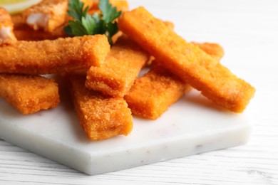 Photo of Tasty fresh fish fingers served on white wooden table, closeup