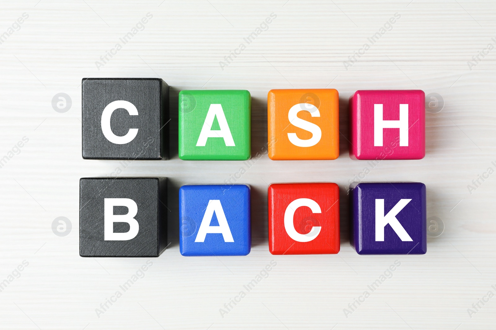 Photo of Colorful cubes with word Cashback on white wooden table, flat lay