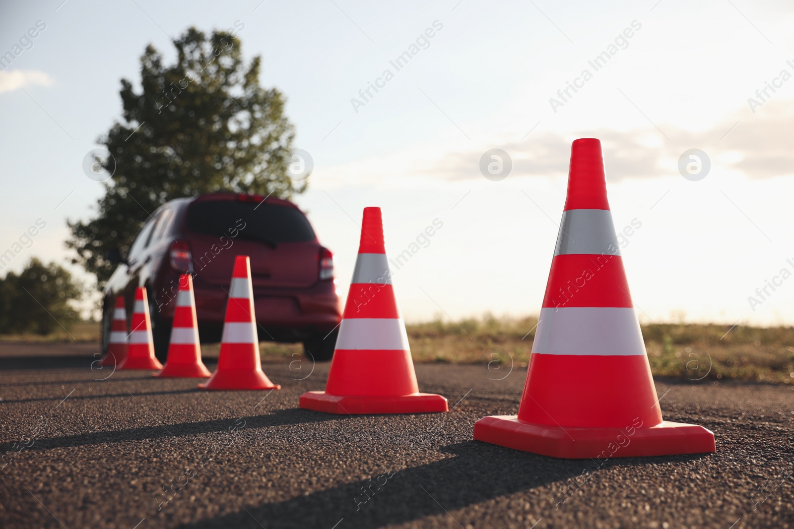 Photo of Traffic cones near car outdoors. Driving school exam