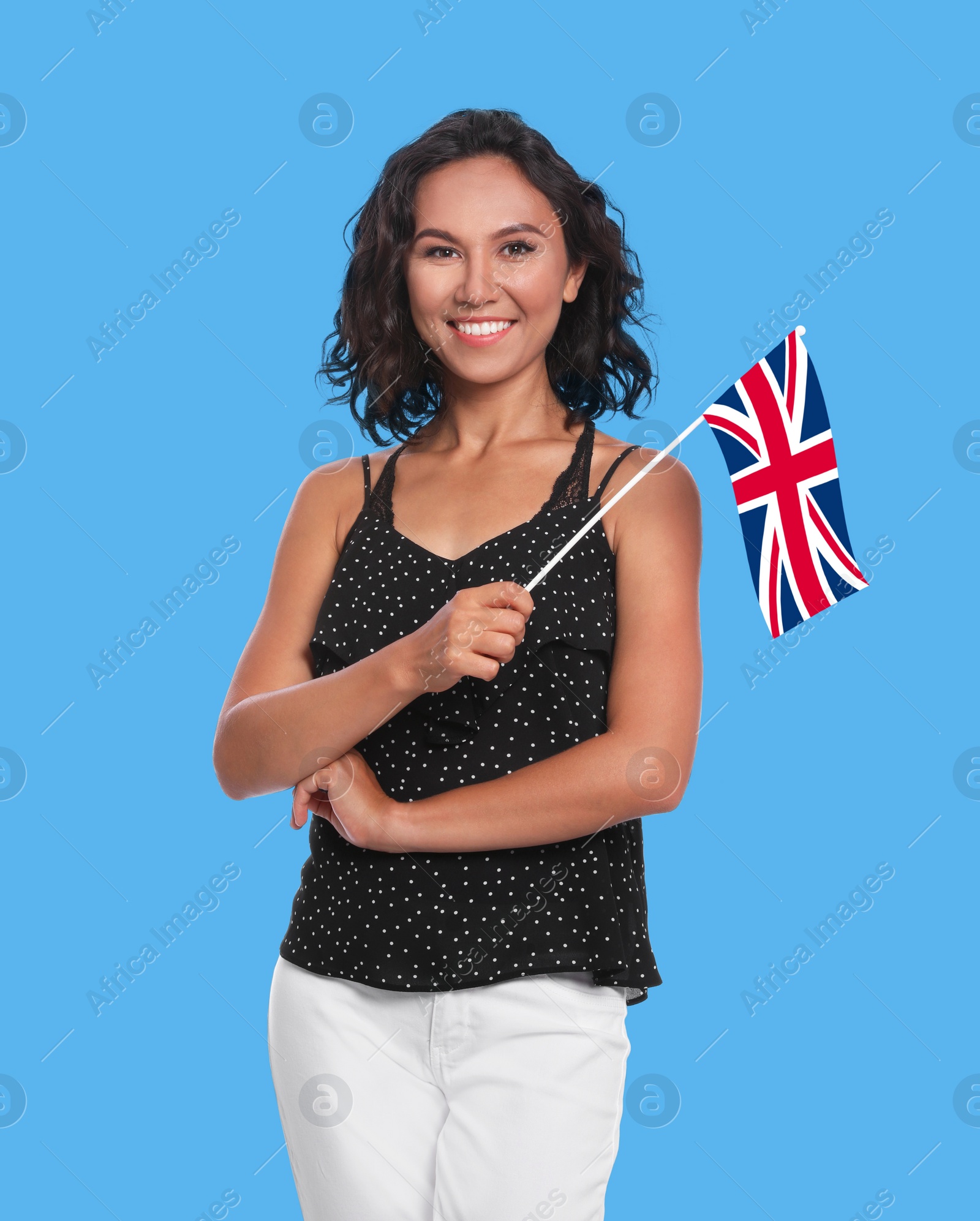 Image of Happy young woman with flag of Great Britain on blue background. Learning English
