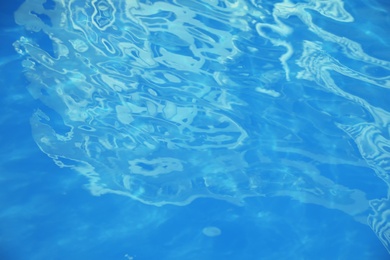 Surface of clean blue water in swimming pool, closeup
