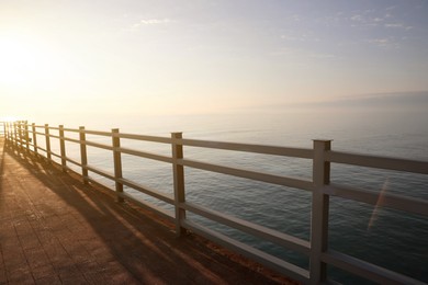Photo of Picturesque view of pier near sea at sunrise