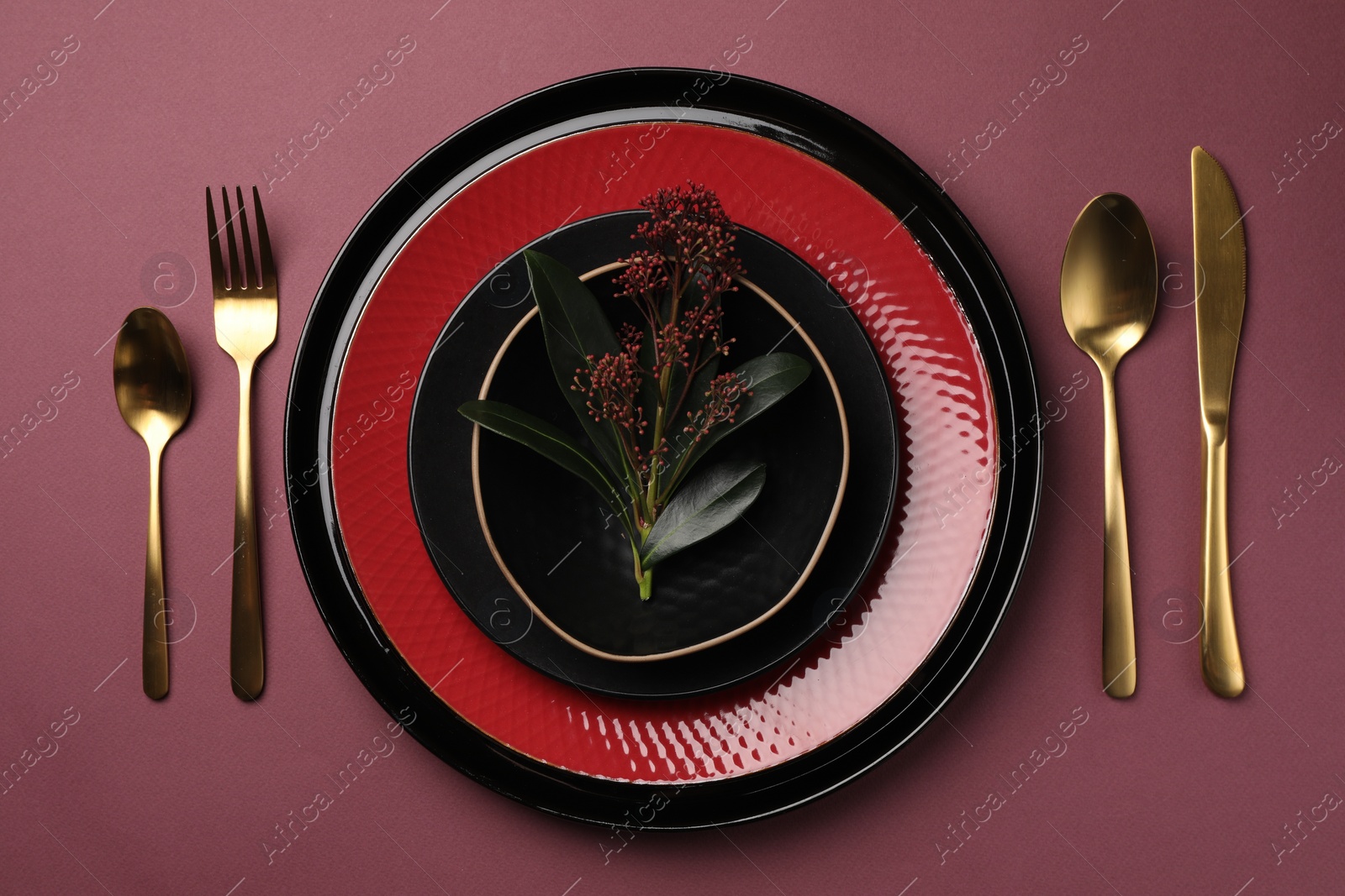 Photo of Stylish table setting with cutlery and floral decor on pink background, flat lay