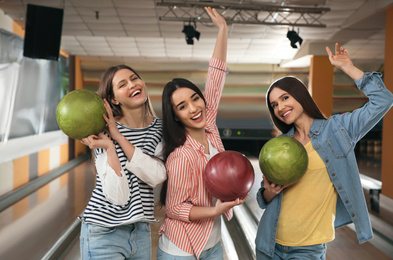 Photo of Group of young women with balls in bowling club