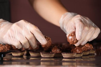 Woman packing delicious candies at production line, closeup