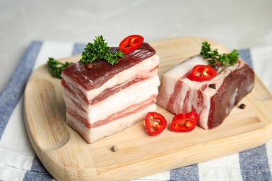 Photo of Board with bacon and pepper on grey background, closeup