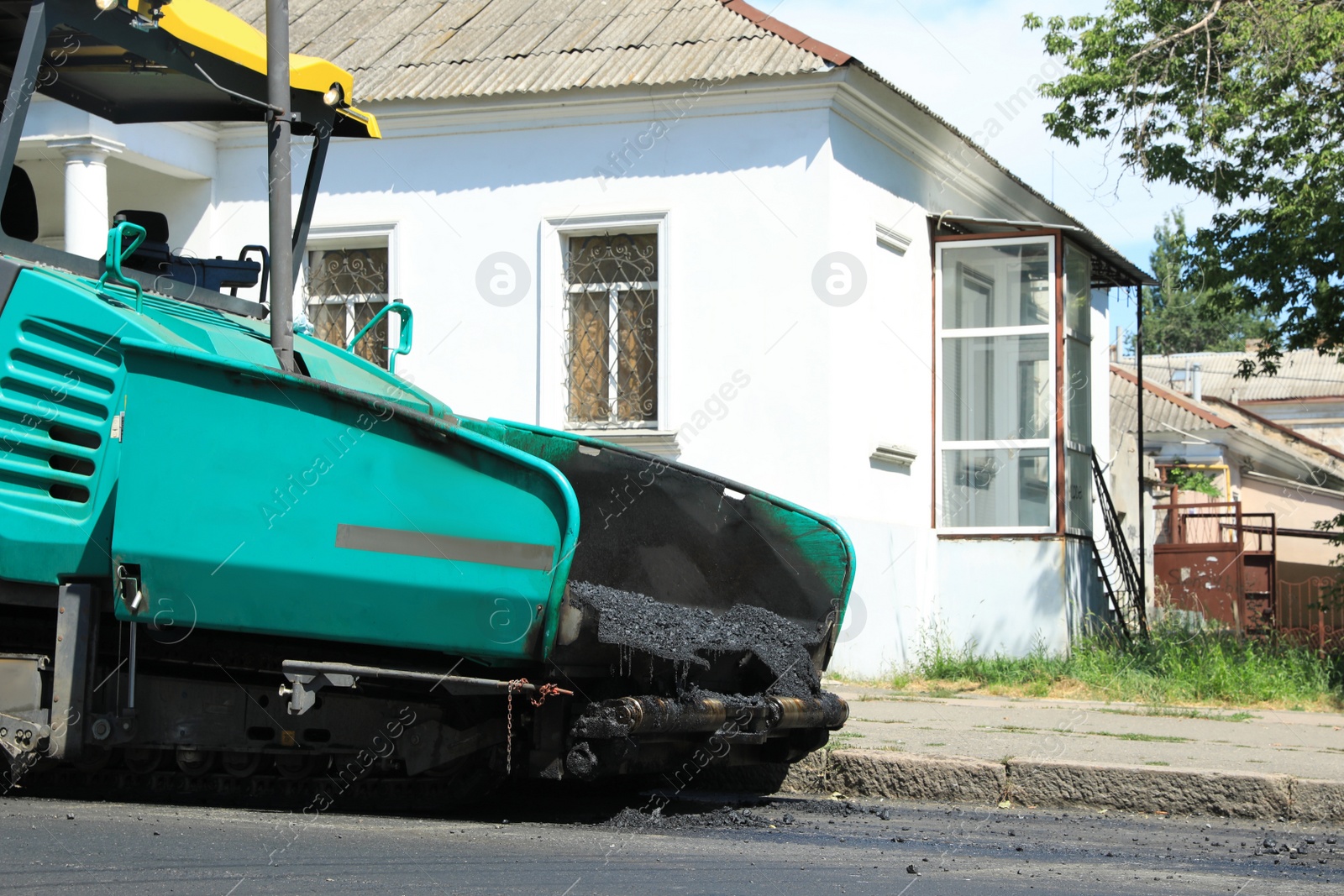 Photo of Asphalt paver working on city street. Road repair