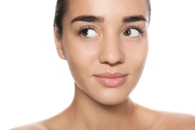 Portrait of young woman with foundation on her face against white background