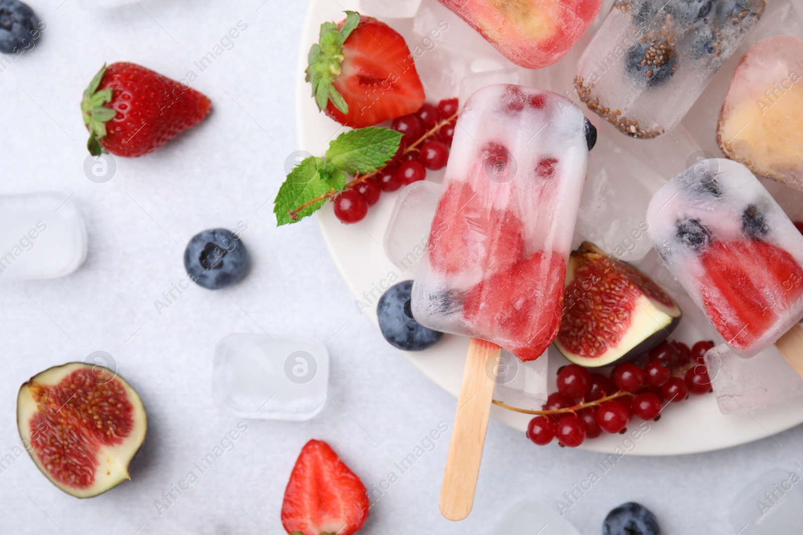 Photo of Flat lay composition with fruit and berry ice pops on white table