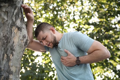 Photo of Man having heart attack near tree in park