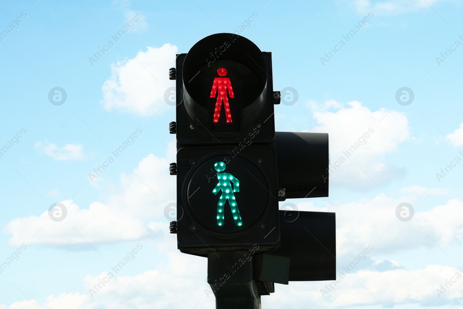 Photo of Traffic lights with green sign against blue sky. Road rules