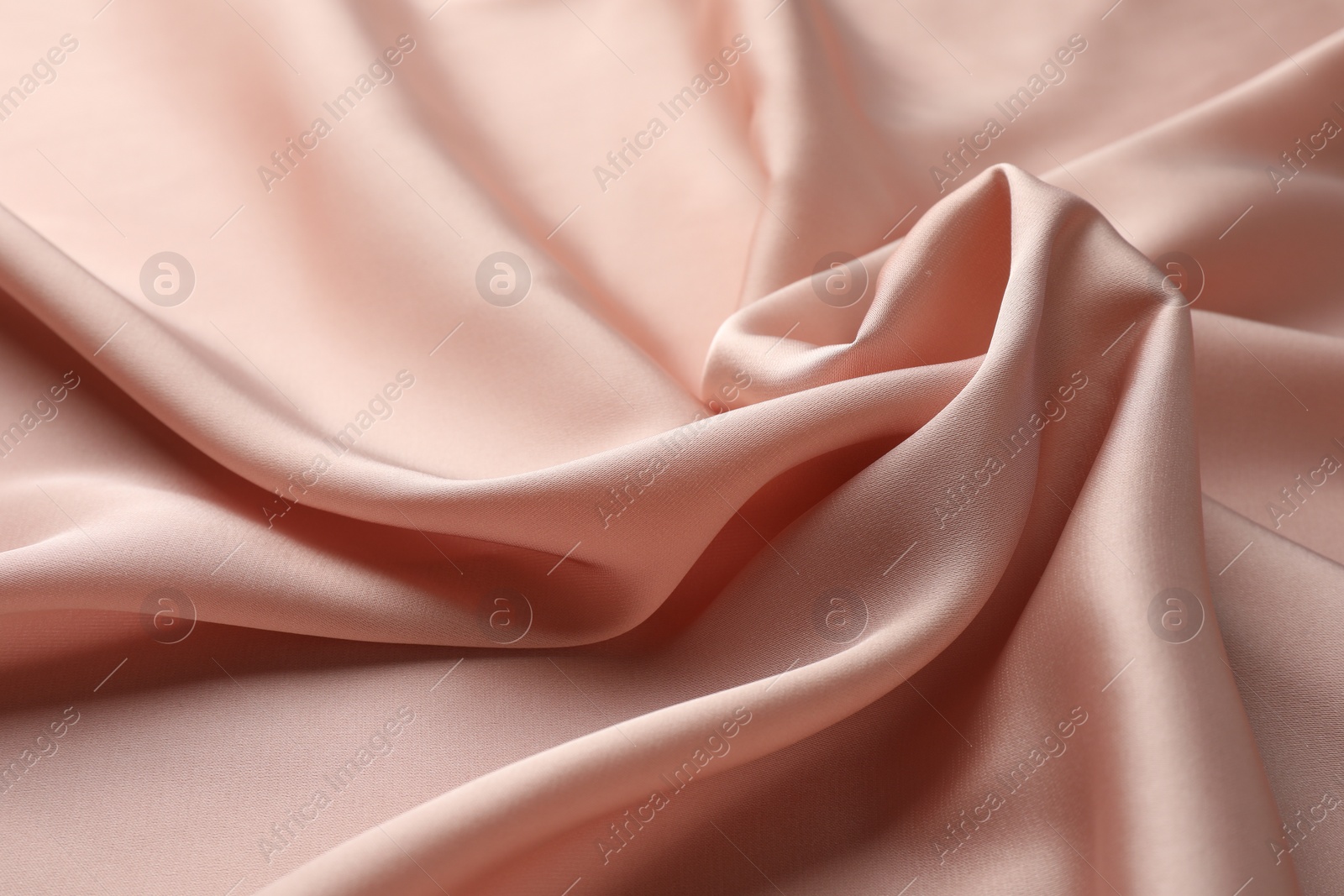 Photo of Crumpled pink silk fabric as background, closeup