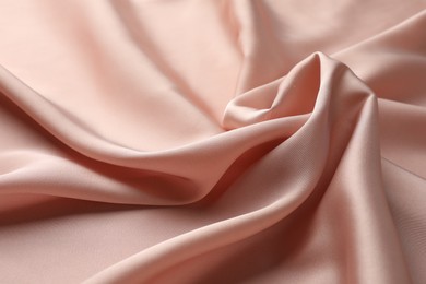 Photo of Crumpled pink silk fabric as background, closeup