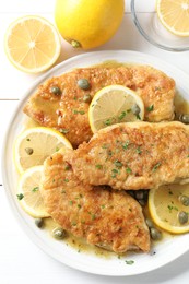 Delicious chicken piccata on white table, top view