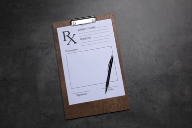 Photo of Clipboard with medical prescription form and pen on dark grey table, top view