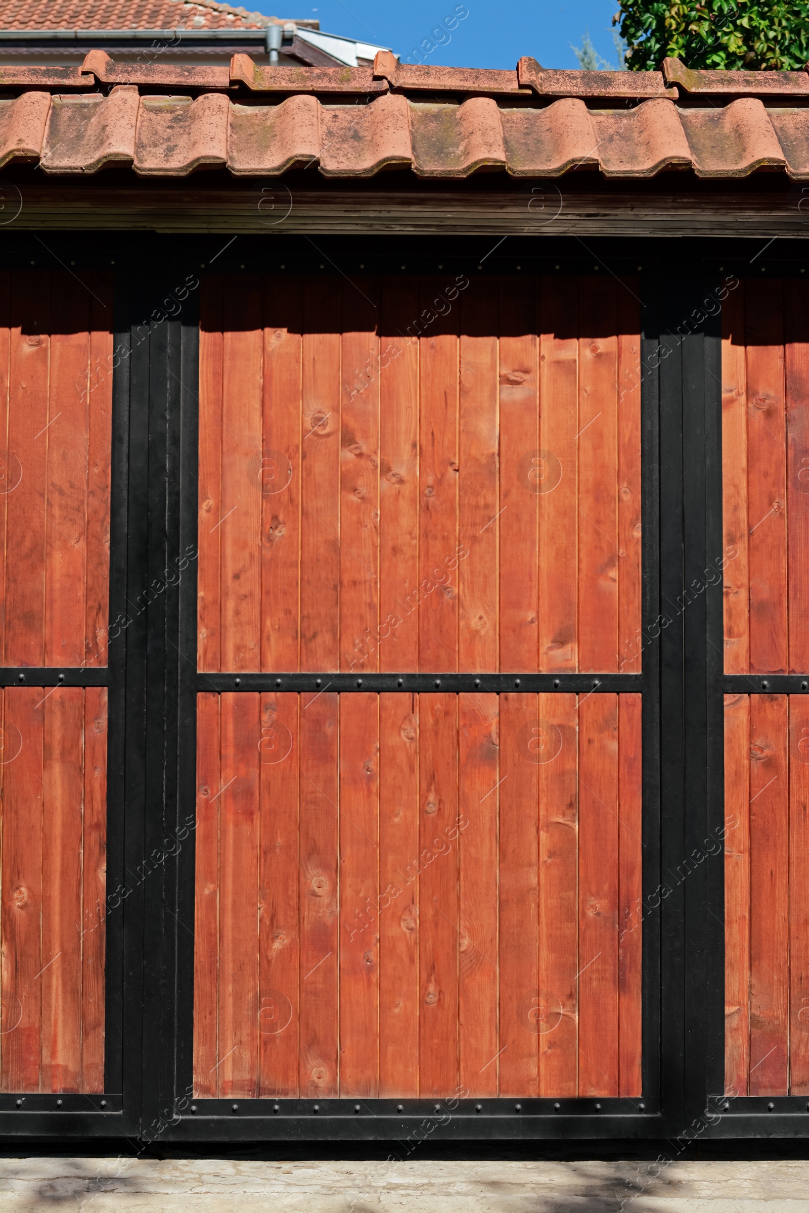 Photo of Metal and wooden fence with roof outdoors