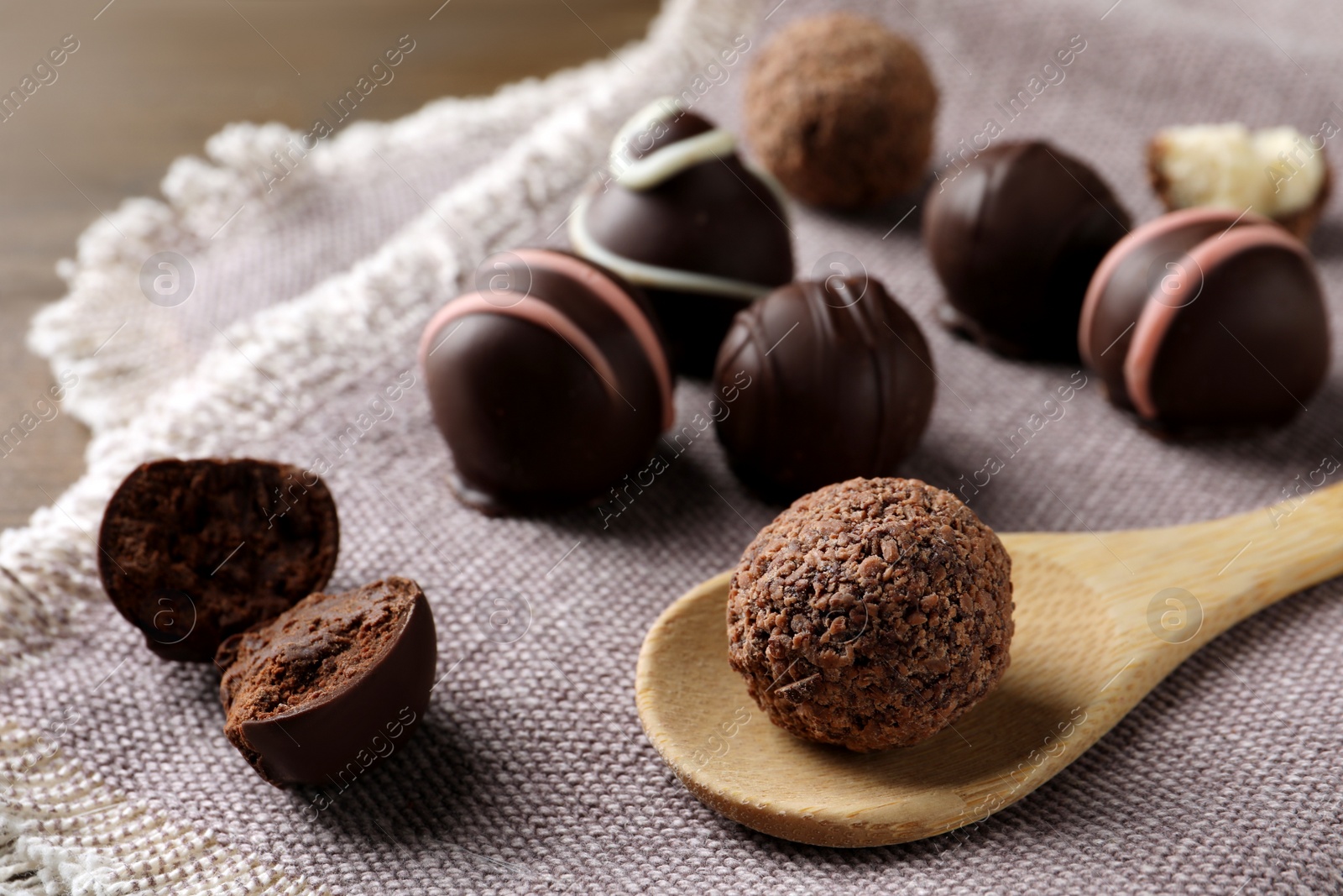 Photo of Many different delicious chocolate truffles on kitchen towel