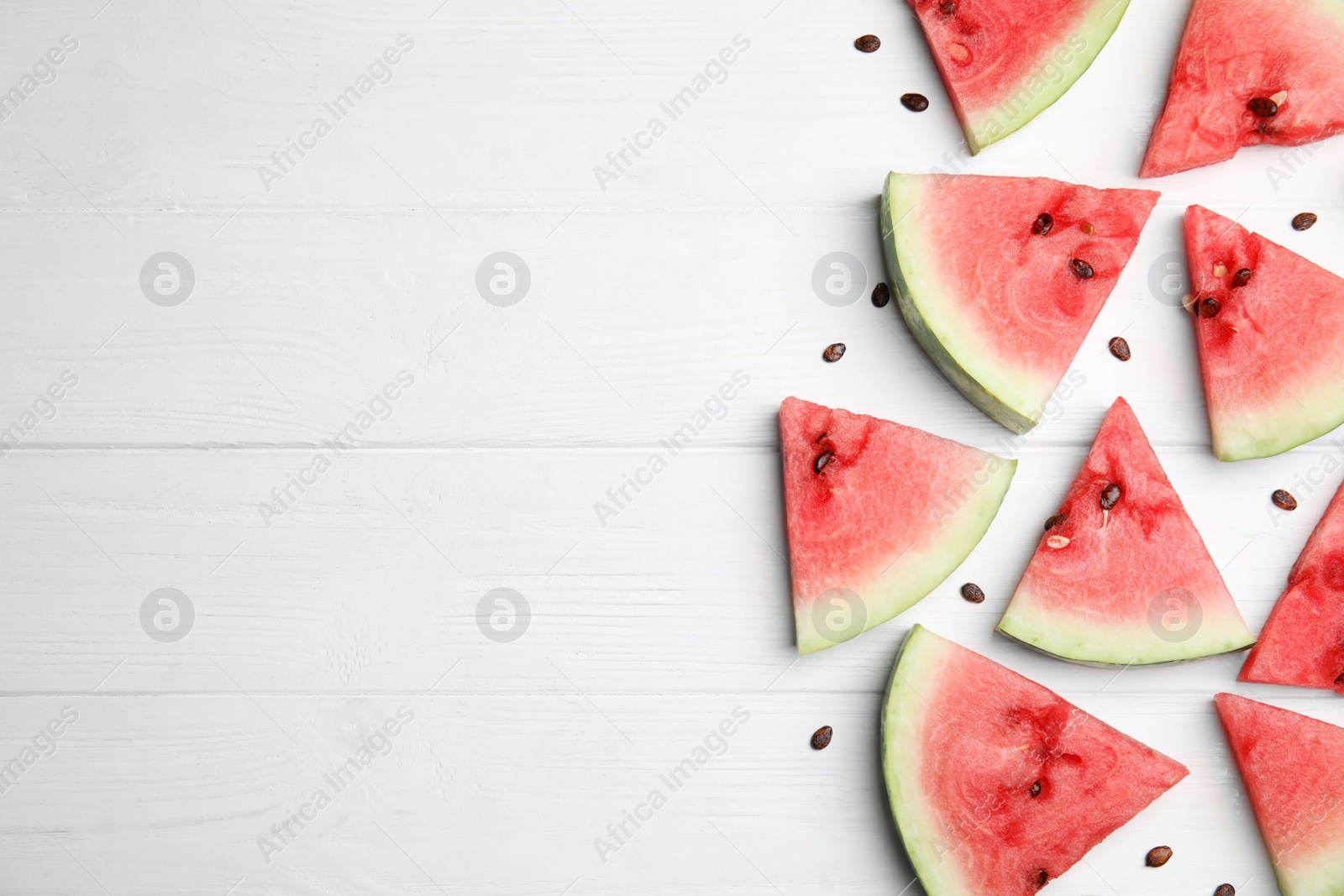Photo of Watermelon slices on white wooden background, flat lay. Space for text