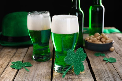St. Patrick's day party. Green beer, decorative clover leaves, leprechaun hat and nuts on wooden table