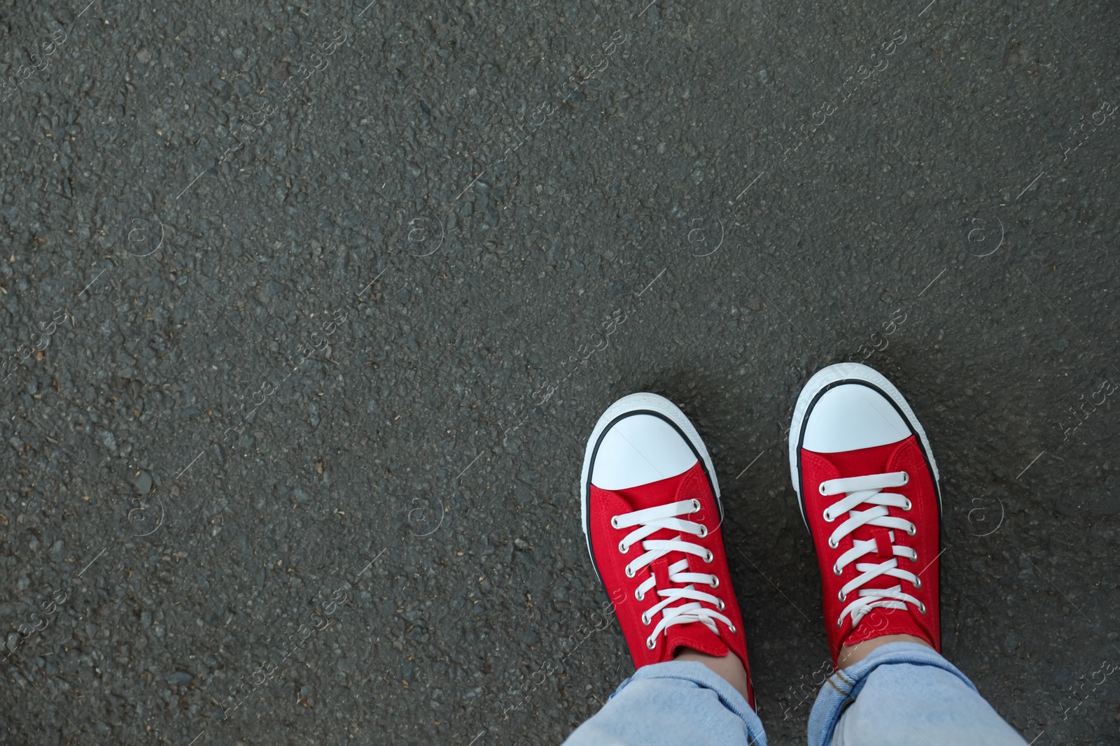 Photo of Woman standing on asphalt, top view. Space for text