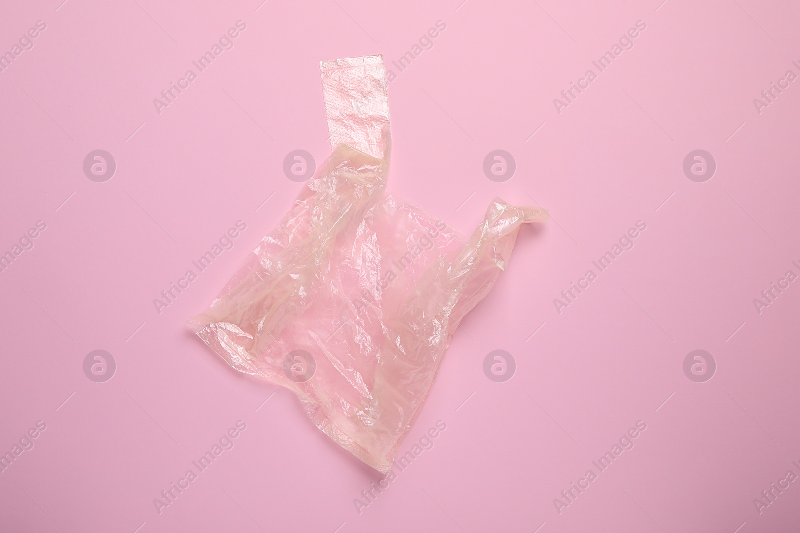 Photo of One plastic bag on pink background, top view. Space for text