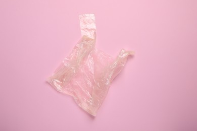 One plastic bag on pink background, top view. Space for text
