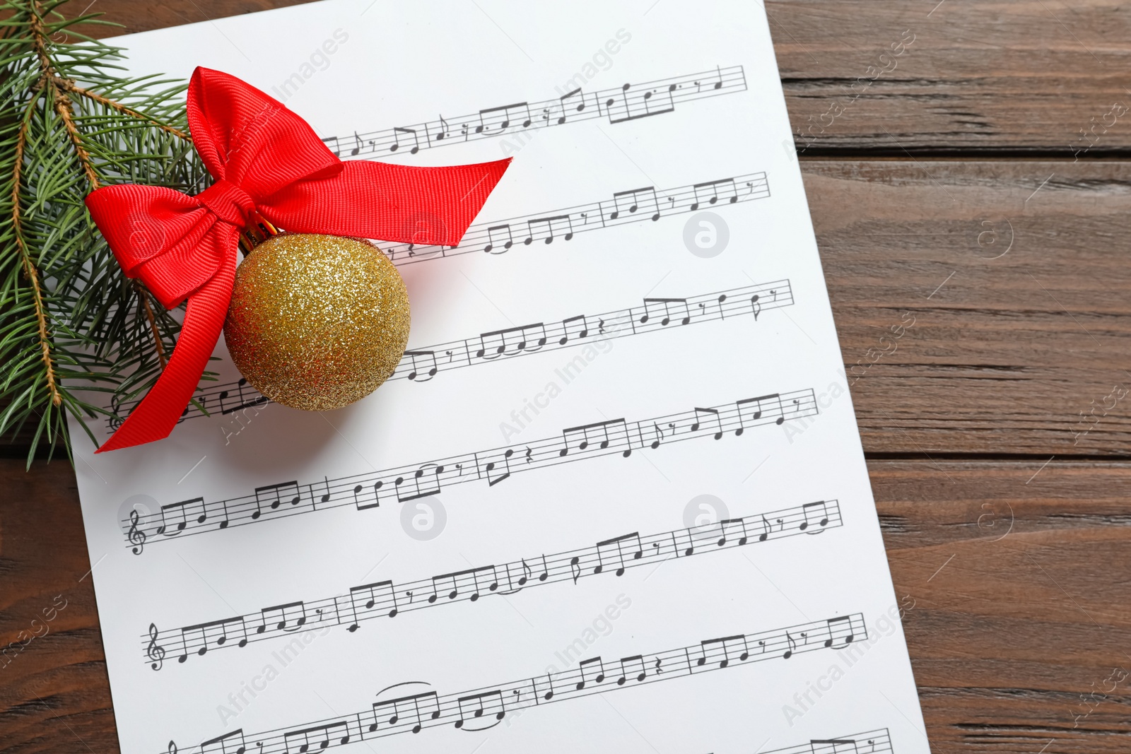 Photo of Flat lay composition with Christmas decorations and music sheet on wooden background