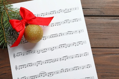 Flat lay composition with Christmas decorations and music sheet on wooden background