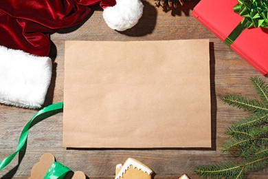 Flat lay composition with empty card and Christmas decorations on wooden table, space for text. Writing letter to Santa Claus