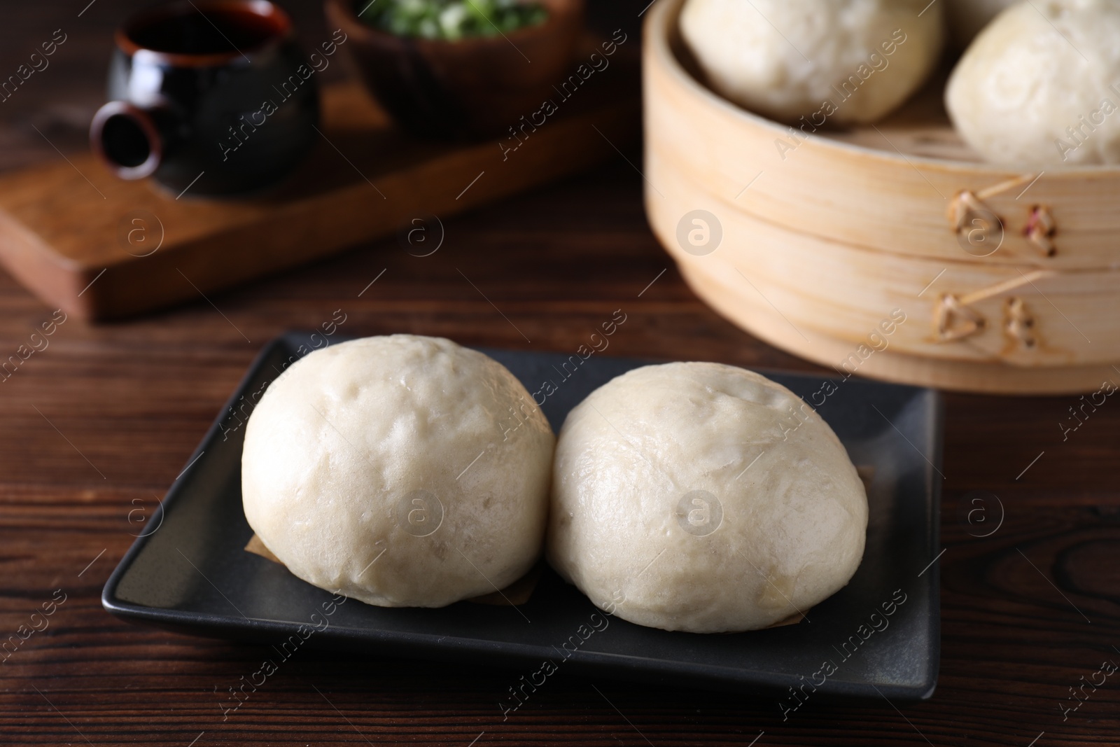 Photo of Delicious Chinese steamed buns on wooden table, closeup