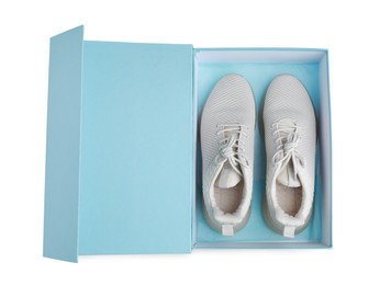 Photo of Pair of stylish sport shoes in turquoise box on white background, top view