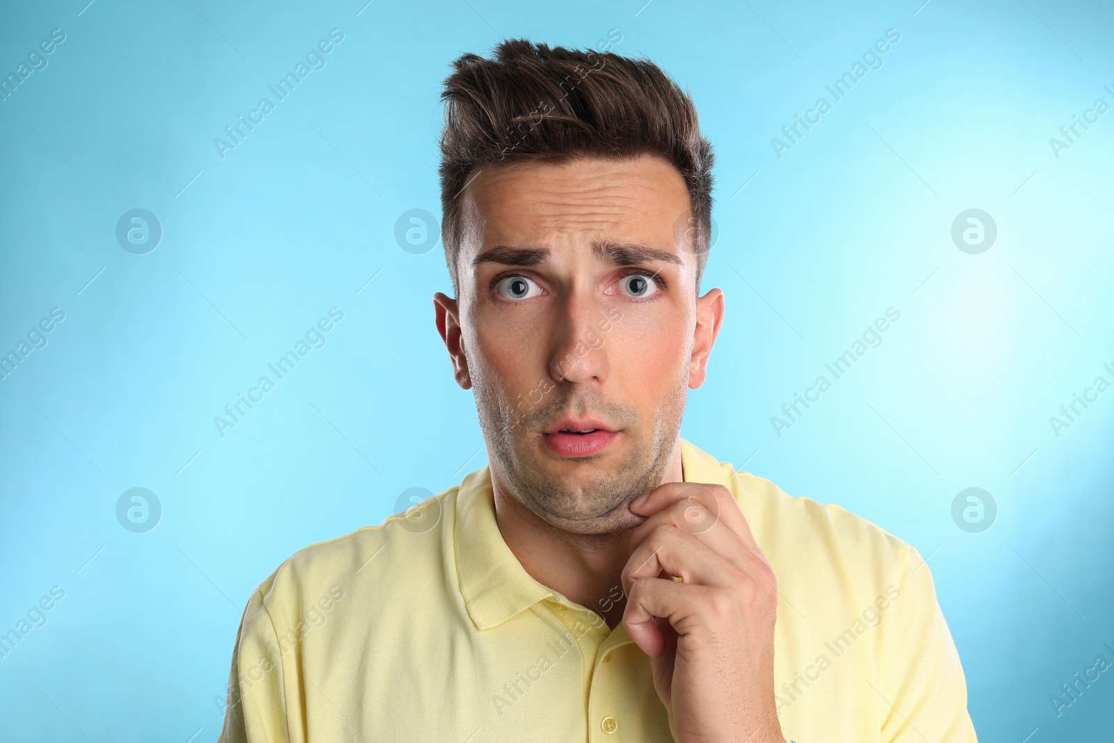 Photo of Emotional young man with double chin on blue background