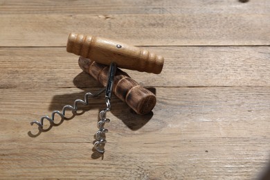 Photo of Two different corkscrews on wooden table, space for text