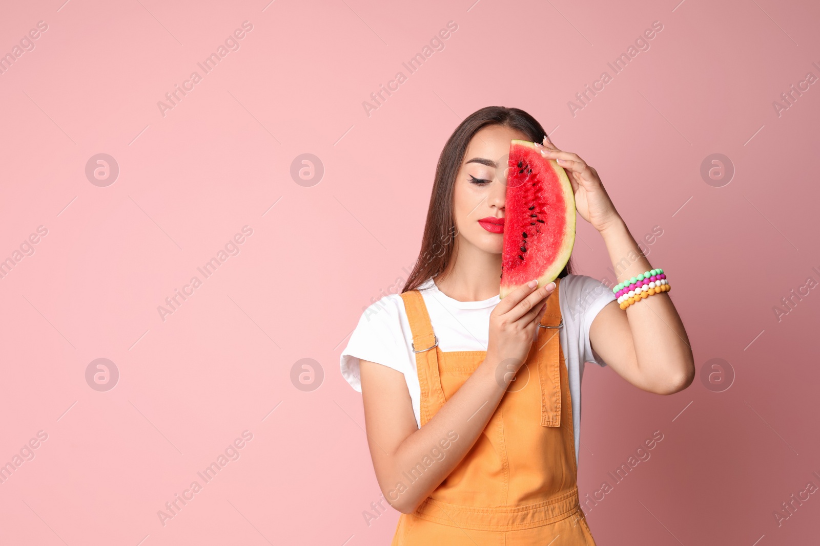 Photo of Beautiful young woman posing with watermelon on color background