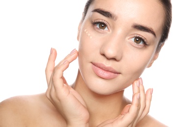 Photo of Portrait of young woman with liquid foundation on her face against white background